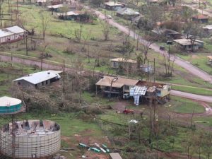 Bare trees and damaged houses and land from a tropical cyclone